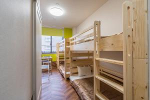 福岡市にあるHOTEL 萃 the 3rd-雑餉隈駅前-無人ホテル-HOTEL SUI the third-ZASSHO-Unmanned Hotelの二段ベッド2台とテーブルが備わる客室です。
