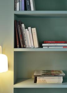 a book shelf filled with books next to a lamp at Hôtel Le Saint Christophe in La Baule