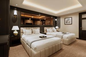 a bedroom with two beds and a couch at The Haron Hanoi Boutique Hotel in Hanoi