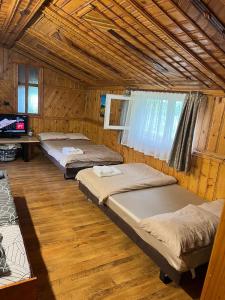 a group of four beds in a room at Cabana "Tăul Brazi" in Roşia Montană