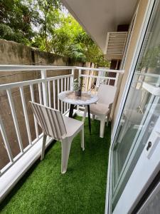a patio with a table and chairs on a balcony at Amani Grand Resort Residences Building C Unit 118 in Pusok