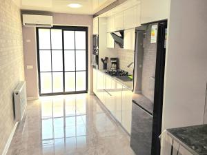 cocina con paredes blancas y ventana grande en Two-Bedroom Apartment in Kutaisi Nest 1, New Linen, Free Parking, en Kutaisi
