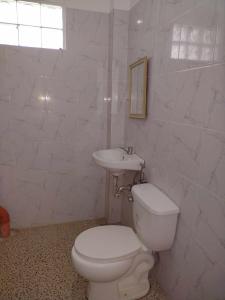 ein weißes Badezimmer mit Toilette und Waschbecken in der Unterkunft Suki Beach Resort "3-3" Family Aircon Room in Sorsogon