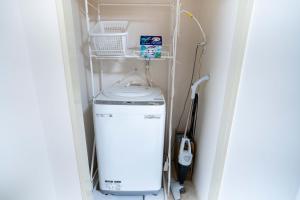 a washer and dryer in a corner of a room at 2 bedrooms and 1 living room on the 1st floor, 40sqm house, 10 min walk to Oji 2 min walk to Kajiyara Toden Arakawa Line in Wada