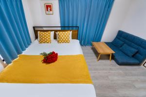 a bedroom with a bed with a yellow blanket and a blue couch at 2 bedrooms and 1 living room on the 1st floor, 40sqm house, 10 min walk to Oji 2 min walk to Kajiyara Toden Arakawa Line in Wada