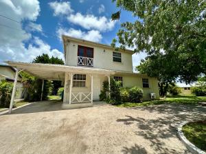 a large white house with a garage at Embassy Villa in Bridgetown