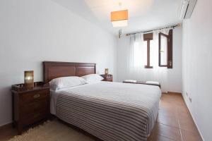 Un dormitorio con una cama y una cómoda y una ventana. en Alojamientos Botica Rural, en La Cabrera