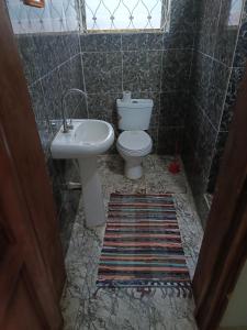 a bathroom with a toilet and a sink at Budget one bedroom apartment in Ibadan +5 photos