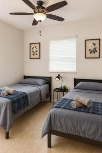 een slaapkamer met twee bedden en een plafondventilator bij Fauna Bizcaya in Gold Coast Heliport