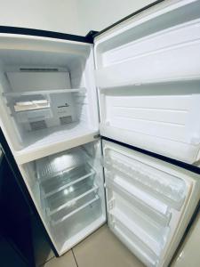 an empty refrigerator with its door open in a kitchen at Michelle Escadia Homestay 29 in Bandar Penawar