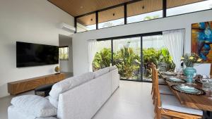 a living room with a couch and a dining room table at Suan Serenity Villa in Koh Samui