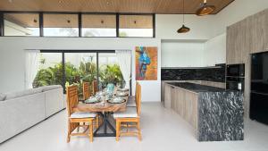 a dining room with a table and chairs and a kitchen at Suan Serenity Villa in Koh Samui