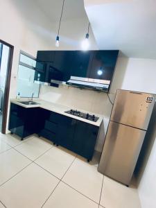 a kitchen with blue cabinets and a stainless steel refrigerator at Michelle Escadia Homestay 29 in Bandar Penawar +11 photos