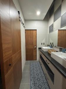 a bathroom with two sinks and a wooden door at New modern house in Qro in El Pueblito