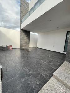 an empty room with a concrete floor and a staircase at New modern house in Qro in El Pueblito