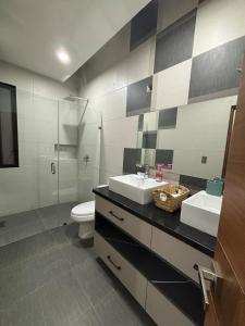 a bathroom with two sinks and a toilet and a shower at New modern house in Qro in El Pueblito +29 photos