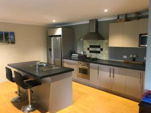 a kitchen with a island in the middle of it at Sun Saturated sanctuary in Timaru