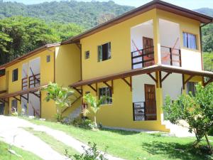 un edificio blanco y amarillo en una colina en Pousada Portal das Estrelas, en Trindade