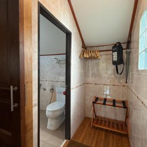 a bathroom with a toilet and a window and a door at Mangrove bungalow & restaurant in Ko Kood