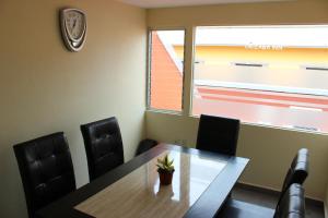a conference room with a table and chairs and a clock at Orizaba Inn in Orizaba