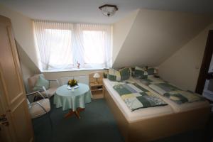 1 dormitorio con cama, mesa y ventana en Parkhotel Phoenix Garni, en Hage
