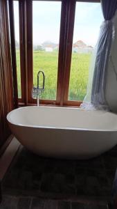 a bath tub in a room with a window at Padma Laya Private Villa 2BR in Sukawati