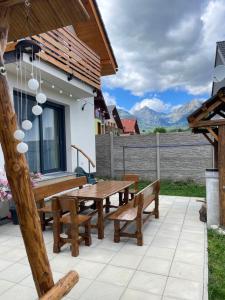 a wooden picnic table and benches on a patio at Vila Mima in Nová Lesná