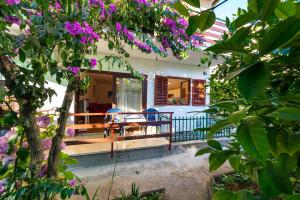 a porch of a house with purple flowers at Apartments Borik in Zadar