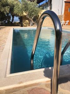a swimming pool with a metal hand rail next to it at Wunderschönes Ferienhaus In Agios Stefanos in Foútia
