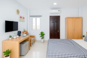 a bedroom with a bed and a desk and a tv at Phan Anh Hotel - Bui Vien Walking Street in Ho Chi Minh City