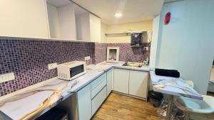a kitchen with white cabinets and a microwave at 7 Star homes at Rajhans Belliza in Surat