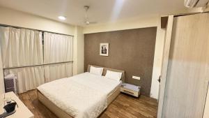 a small bedroom with a bed and a desk at 7 Star homes at Rajhans Belliza in Surat