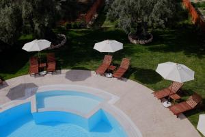 widok na basen z parasolami w obiekcie Kamares Luxury Apartments w mieście Leukada (miasto)