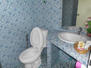 ein blau gefliestes Badezimmer mit Toilette und Waschbecken in der Unterkunft Phu Resort in Ban Choko + 194 Fotos