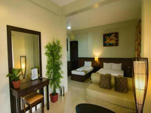 a hotel room with a bed and a couch at Driggs Pension House in General Santos