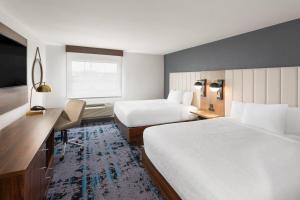 a hotel room with two beds and a desk at La Quinta by Wyndham Springdale in Springdale +26 photos