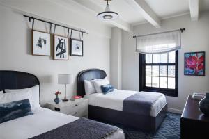 a bedroom with two beds and a window at Hotel Figueroa, Unbound Collection by Hyatt in Los Angeles