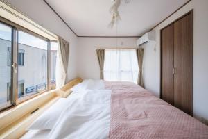 a bedroom with a bed and a window at Laughter in Fuchu