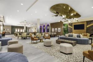 a hotel lobby with couches and tables and a television at Hilton Garden Inn Nashville Opryland in Nashville