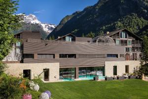 una casa en las montañas con un patio en Mirtillo Rosso Family Hotel, en Alagna Valsesia