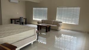 a bedroom with a bed and a couch and a chair at Wildlife Oasis in Marloth Park