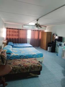 a bedroom with two beds and a ceiling fan at impact เมืองทองธานี ห้องเช่ารายวัน pupular condo เมืองทอง in Thung Si Kan