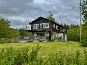 a large house with a large grassy field at Big House With A View Over Forest Lake in Hölö