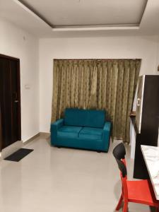a blue couch in a living room with a window at Dhavika stay eat n celebrate in Jāmb