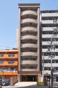 an apartment building with a parking lot in front of it at Rintow Nagoya Takaoka STAY in Nagoya +41 photos
