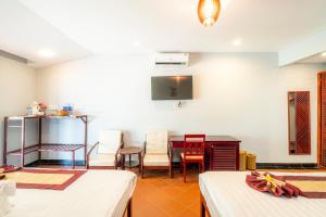 a room with two beds and a table and chairs at Thai Hoa Mui Ne Resort in Mui Ne