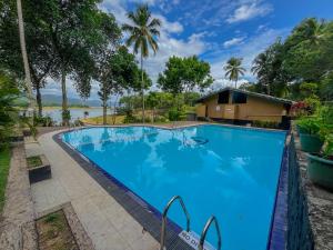 a swimming pool in front of a house at Oruthota Chalets in Kandy
