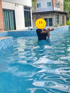 a man holding a frisbee in a swimming pool at Riverside Khao Yai in Ban Khanong Phra Klang (1)