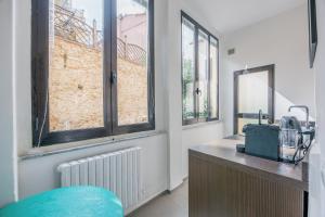 a room with a counter with a sink and windows at Loge d'Art - Centro Storico di Arezzo in Arezzo