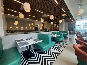 a restaurant with green chairs and tables in a room at Dasara Executive in Tuljapur